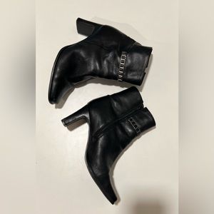 Markon black leather booties with heels, zipper and striking accents.